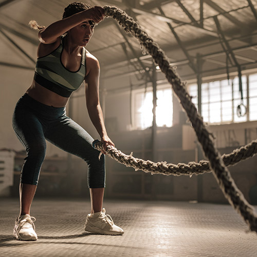 Woman working out with heavy ropes