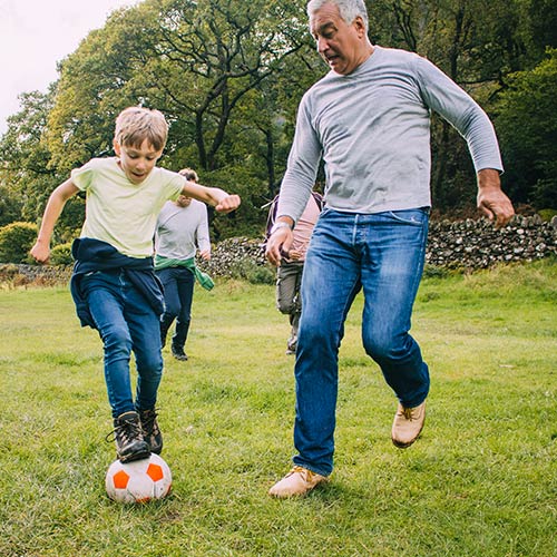 Grandfather playing soccer with grandson